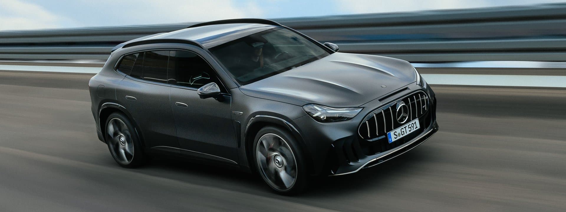 Matte grey Mercedes-AMG GT SUV driving on a highway, front three-quarter view