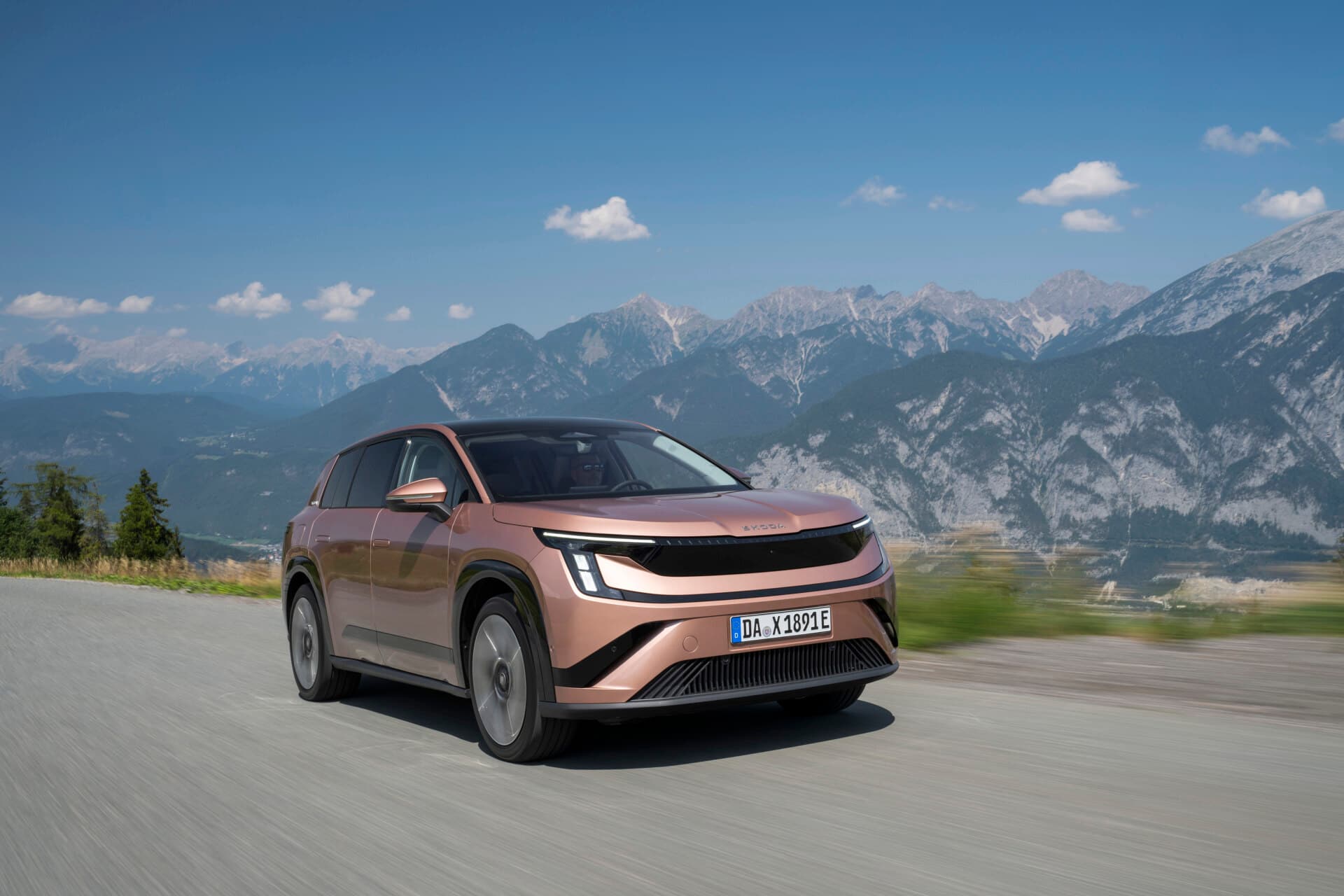 Copper Škoda Peaq battery SUV driving on a mountain road, front three-quarter view, German dealer plate DA X 1891 E