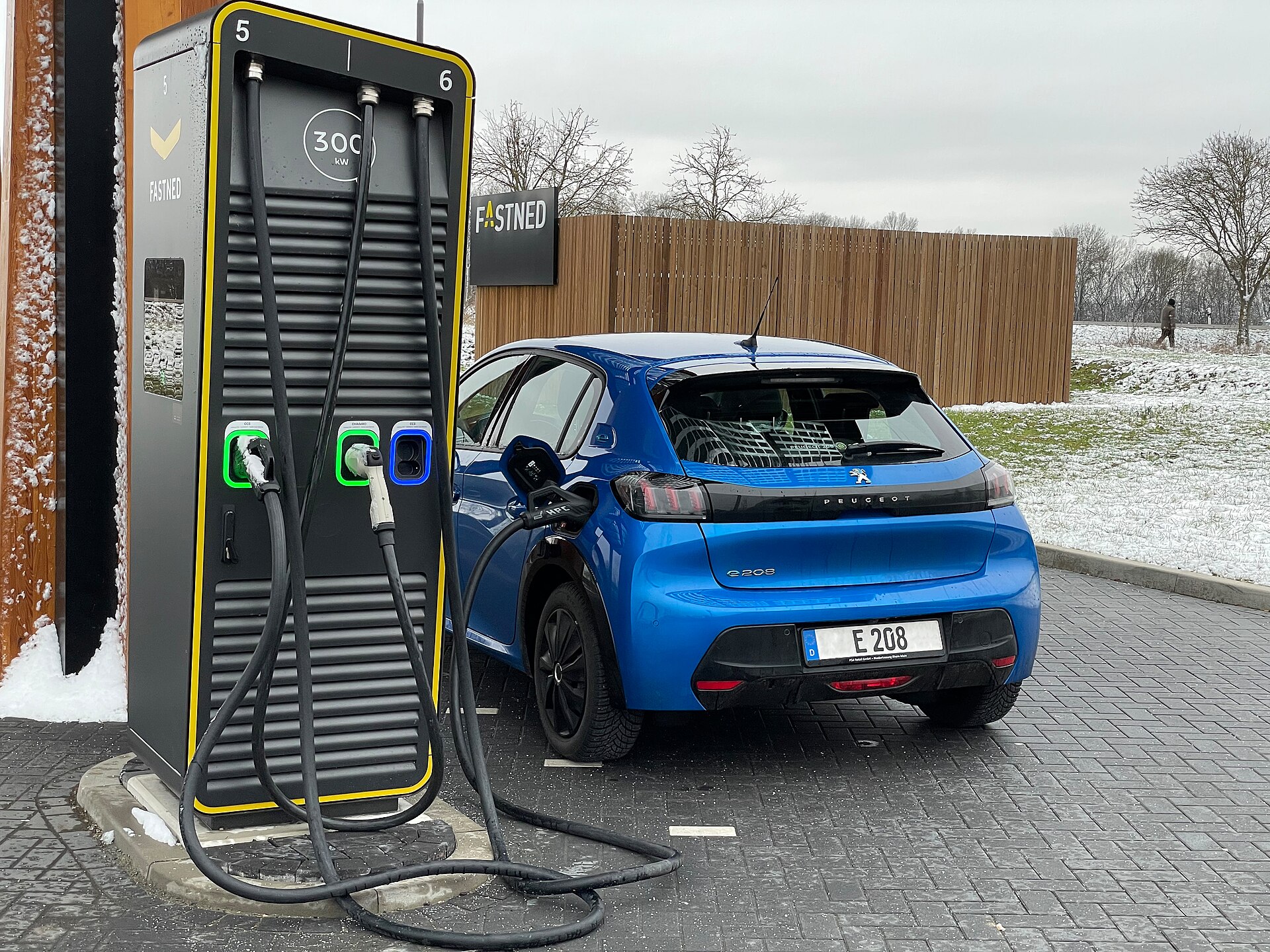 Electric car on a high-power CCS fast charger, illustrating megawatt-class public charging hardware