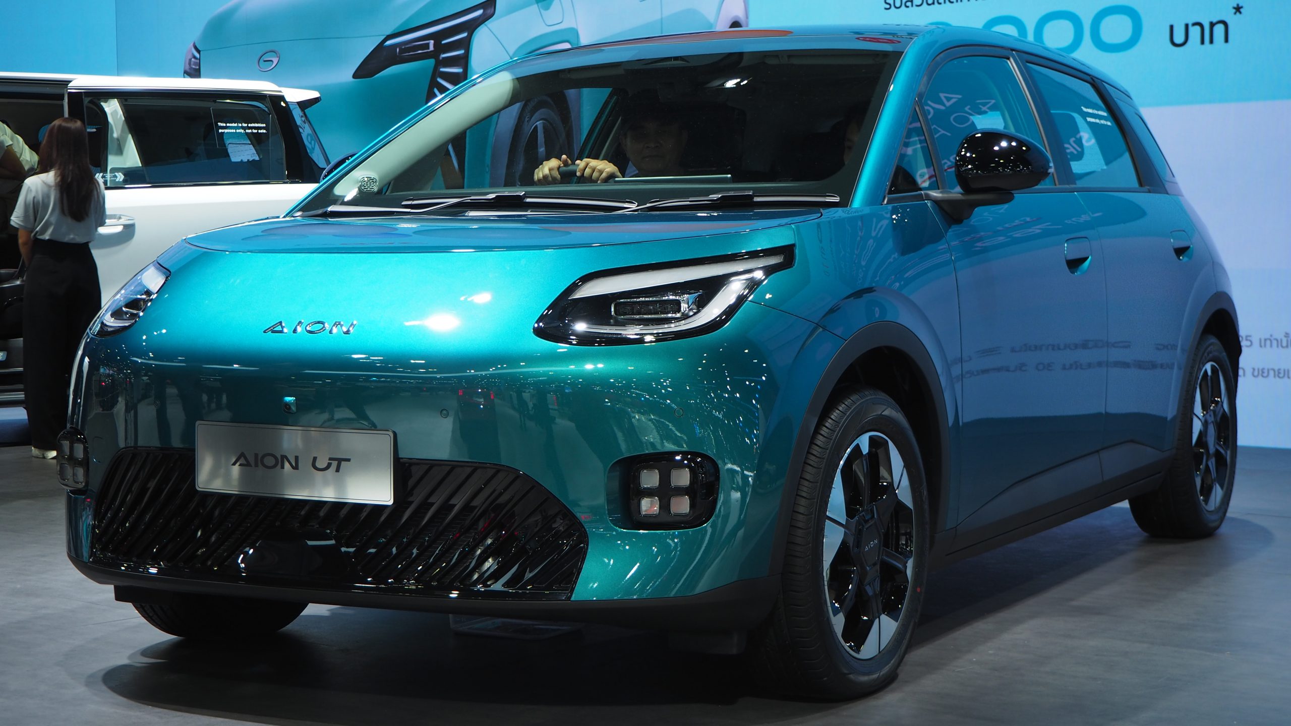 AION UT electric hatchback, front three-quarter view, on a motor show stand