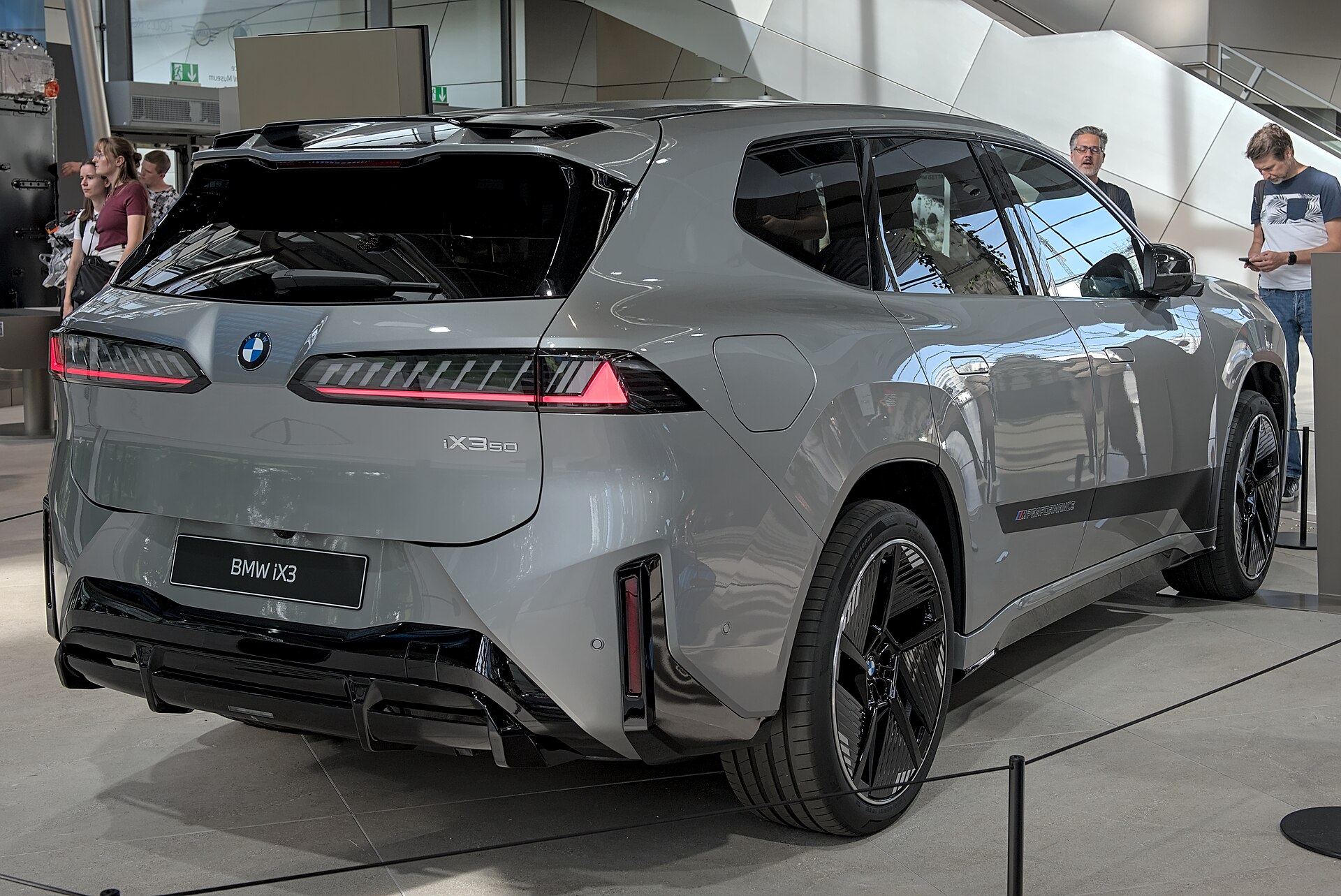 Grey BMW iX3 NA5 battery SUV at IAA 2025, front three-quarter view on a show stand