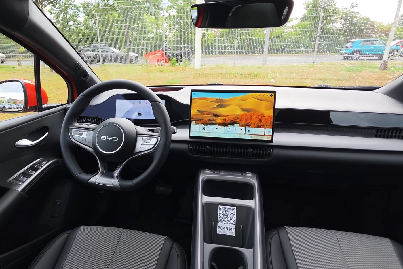 Interior of a BYD Dolphin G DM-i Comfort showing the steering wheel, digital driver display and central touchscreen