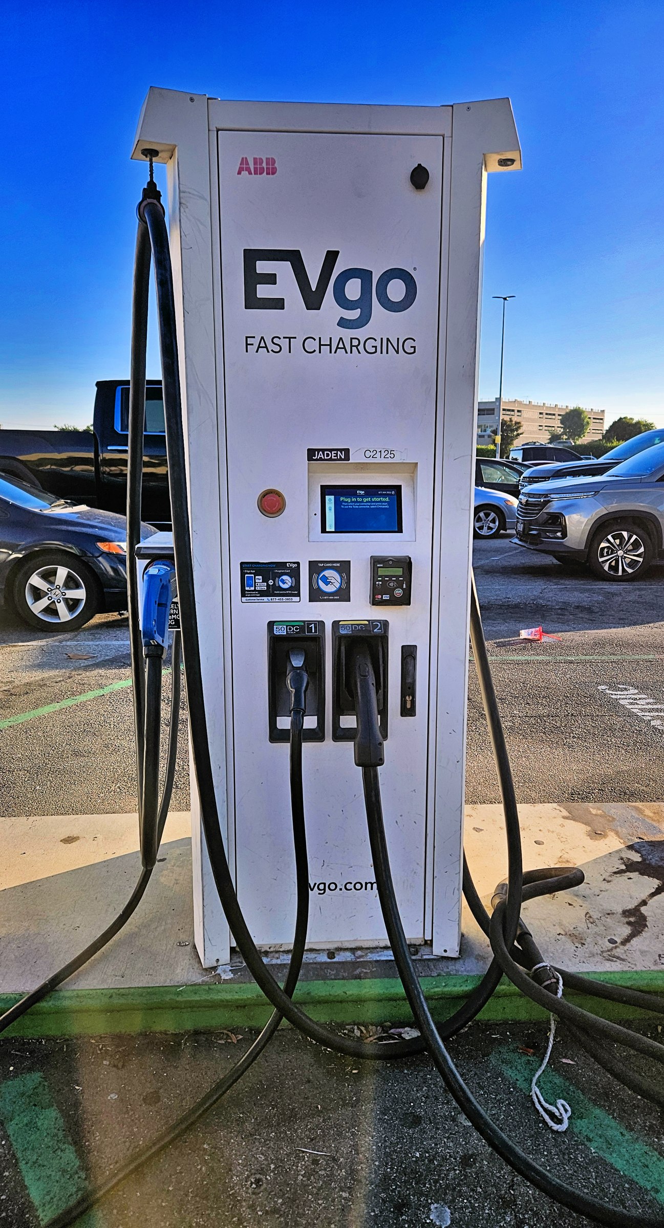EVgo DC fast charger with NACS and CCS1 connectors at a shopping mall parking lot