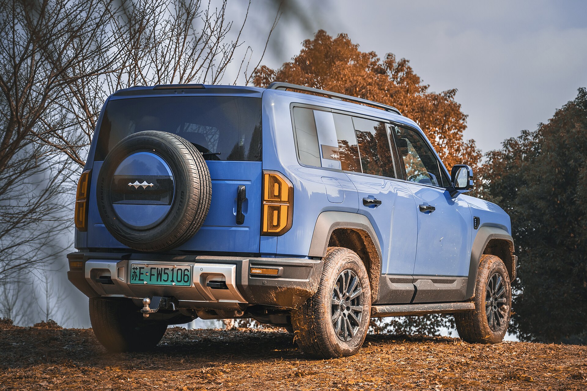 Orange Fang Cheng Bao Bao 5 boxy off-road SUV, front three-quarter view in a city
