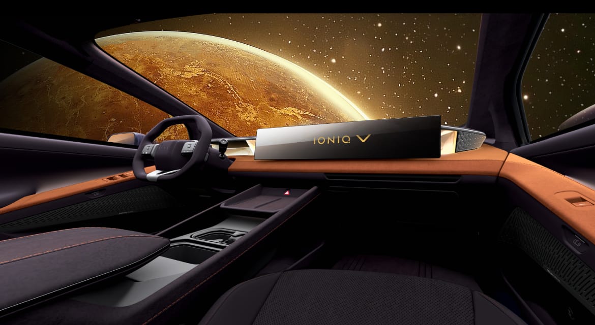 Hyundai Ioniq V cabin with a wide dashboard screen and oval steering wheel