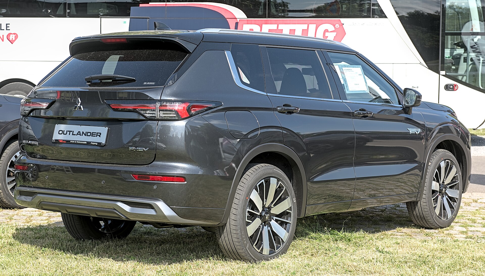 Black 2025 Mitsubishi Outlander plug-in hybrid SUV, front three-quarter view at Automobil Messe Bietigheim