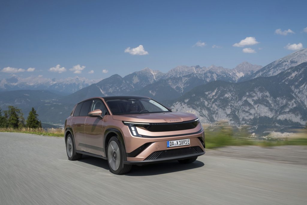Copper Škoda Peaq battery SUV driving on a mountain road, front three-quarter view, German dealer plate DA X 1891 E