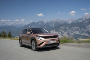 Copper Škoda Peaq battery SUV driving on a mountain road, front three-quarter view, German dealer plate DA X 1891 E