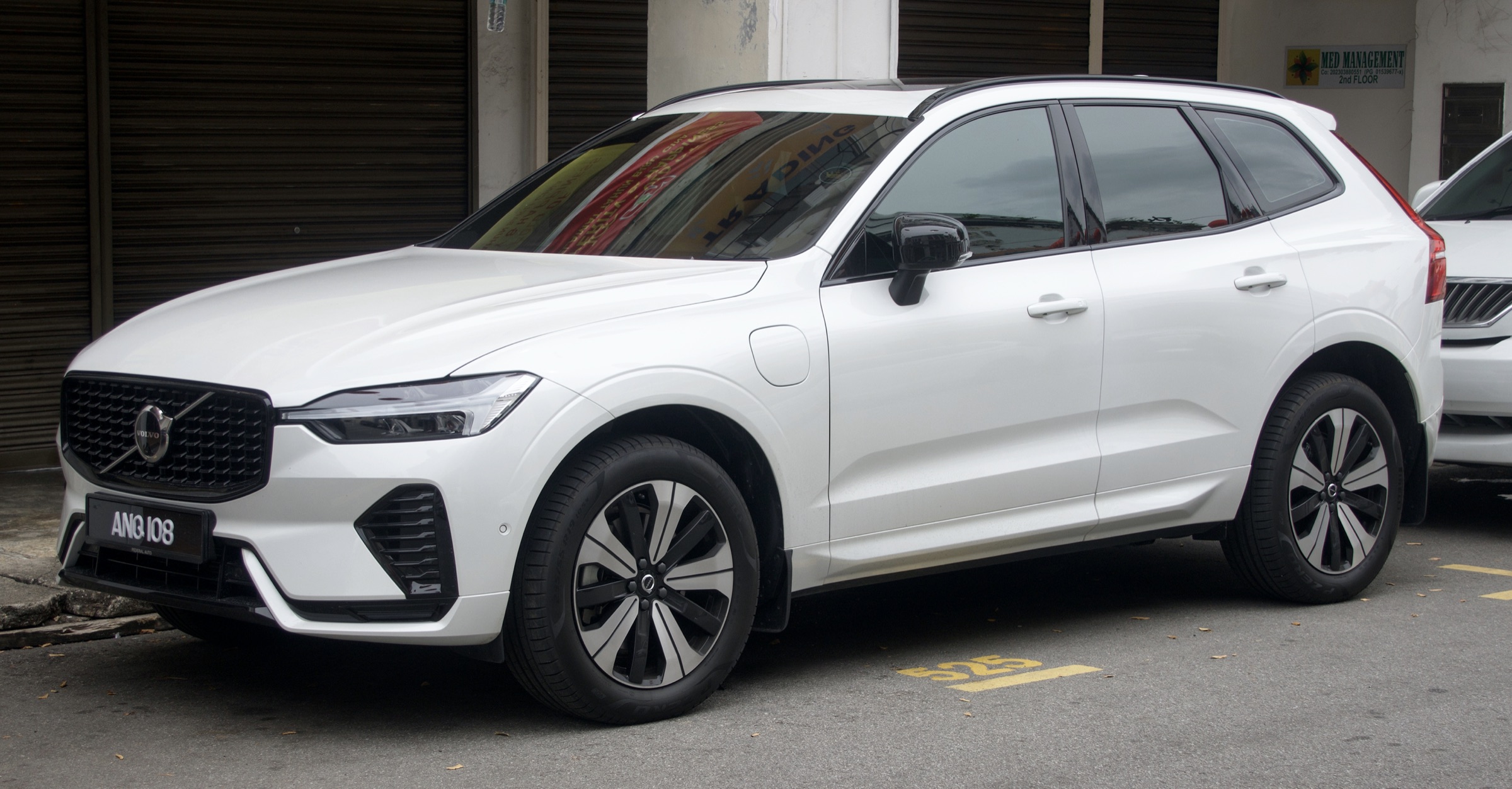 White 2023 Volvo XC60 T8 R-Line plug-in hybrid SUV, front three-quarter view in Penang, Malaysia