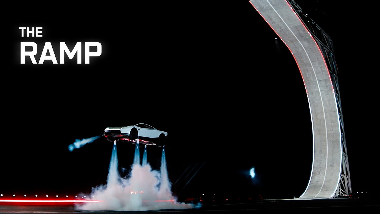 White Tesla Roadster prototype airborne beside a curved ramp at night, with cold-gas jets firing beneath the car