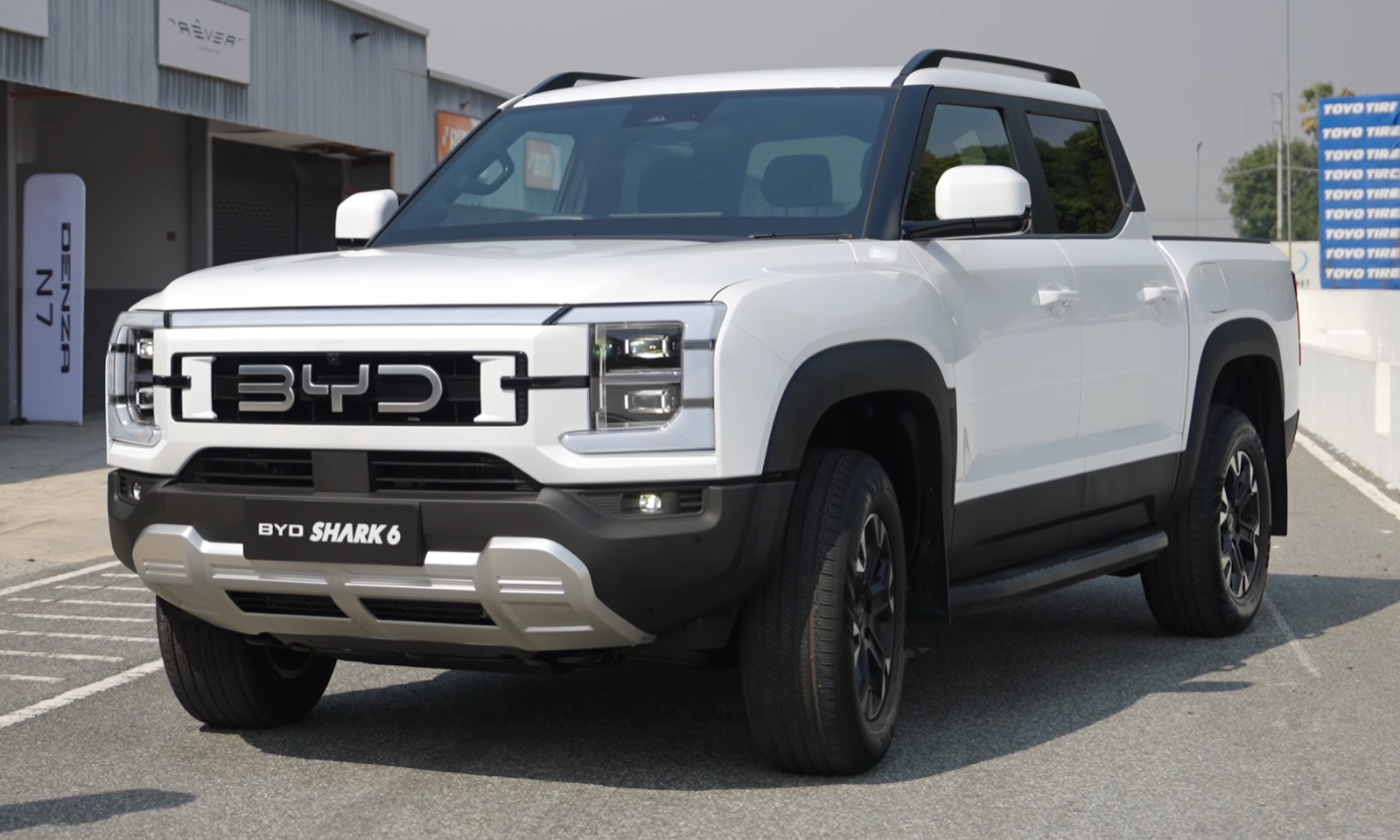 Front three-quarter view of a white BYD Shark 6 plug-in hybrid pickup