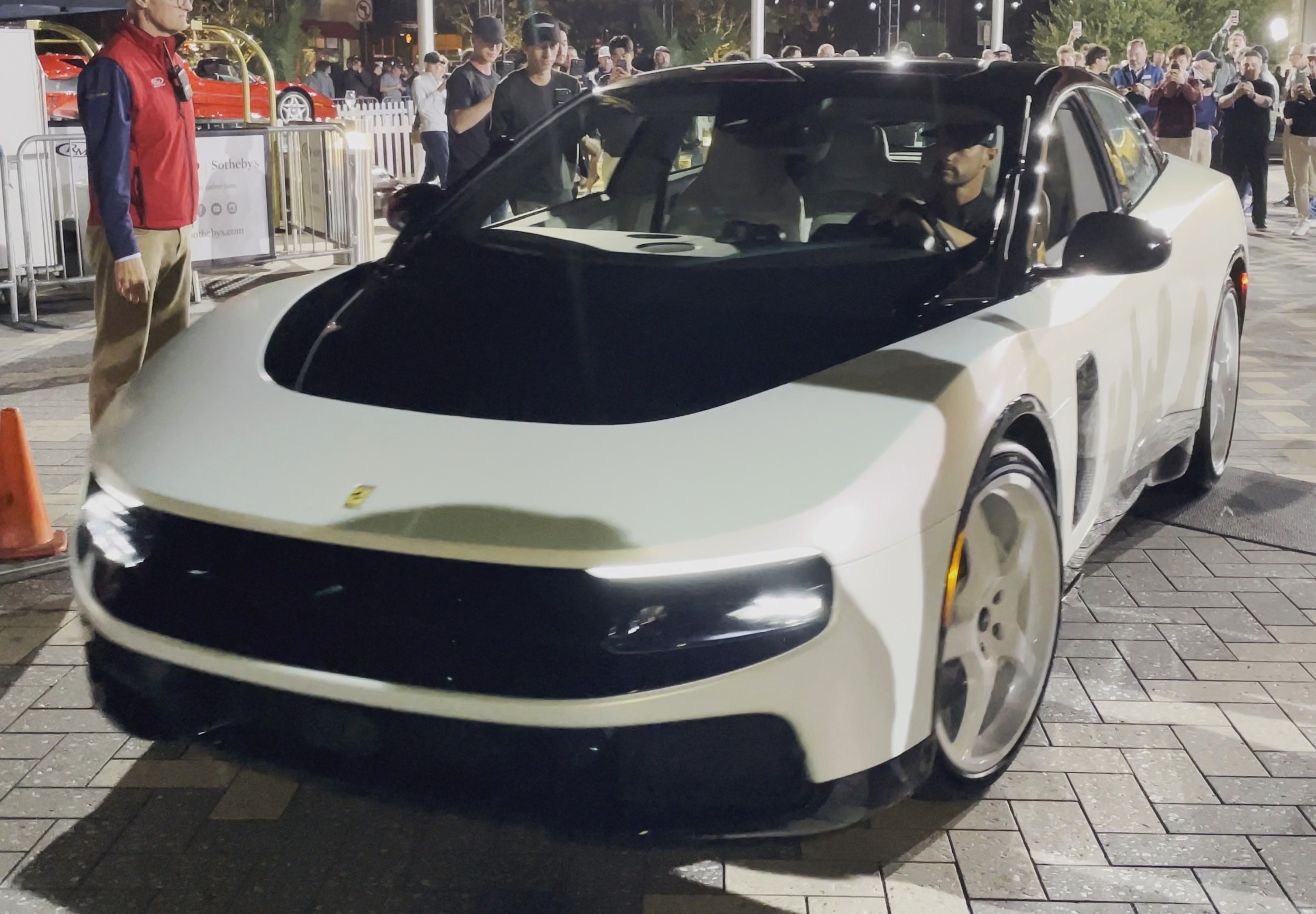 White Ferrari Luce at a nighttime Monterey auction, front three-quarter view