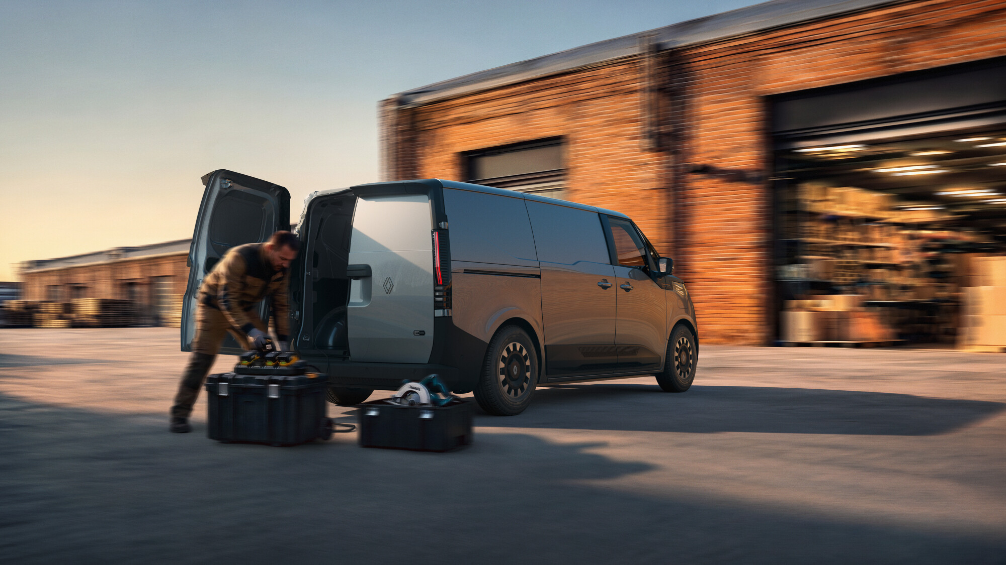 Renault Trafic Van E-Tech electric van with rear barn doors open while a worker unloads tools